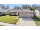 Well-maintained single-story home with a tidy lawn and a convenient two-car garage at 11018 Courtland St, Trinity, FL 34655
