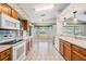 Open-concept kitchen featuring wood cabinets, white appliances, and sunlit breakfast nook at 11018 Courtland St, Trinity, FL 34655