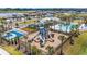 Aerial view of community area with playground, pool, clubhouse, basketball court, and lush landscaping at 1274 Ocean Spray Dr, Ruskin, FL 33570