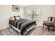 Bright bedroom with a black and white striped bed, carpeted floors, and a window for natural light at 1274 Ocean Spray Dr, Ruskin, FL 33570