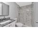 Updated bathroom featuring elegant marble-style tile in shower, a granite vanity, and modern fixtures at 1350 Brixton Ln, Holiday, FL 34691