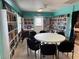 A library with shelves of books, a round table with chairs, and an exit door at 14132 89Th Ave, Seminole, FL 33776
