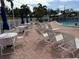 Community pool with lounge chairs and tables in a sunny location surrounded by a white fence at 14132 89Th Ave, Seminole, FL 33776