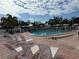 Community swimming pool featuring lounge chairs, a brick patio, and a safety fence at 14132 89Th Ave, Seminole, FL 33776