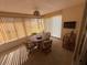 Bright sun room with a round table, four chairs and vertical blinds letting in natural light at 14132 89Th Ave, Seminole, FL 33776