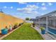 Beautiful backyard featuring a screened-in pool, green lawn and decorative potted plants at 1721 Loriana St, Brandon, FL 33511