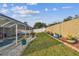 Lush backyard featuring a screened-in pool, well-maintained lawn and manicured landscaping at 1721 Loriana St, Brandon, FL 33511