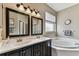Bathroom with double sinks, large mirrors, and a separate soaking tub at 1721 Loriana St, Brandon, FL 33511