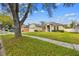 Charming single-Gathering home with a well-manicured lawn, mature trees and a welcoming blue front door at 1721 Loriana St, Brandon, FL 33511