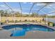 Beautiful pool with a waterfall feature, surrounded by lush landscaping and a screened enclosure at 1721 Loriana St, Brandon, FL 33511
