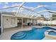 Serene pool area with a jacuzzi, covered patio, and lush landscaping, perfect for relaxing and entertaining at 1721 Loriana St, Brandon, FL 33511
