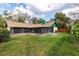 Beautiful backyard view showcasing the home's exterior, large screened-in lanai, and ample green space at 1740 Shady Leaf Dr, Valrico, FL 33596