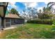 Expansive backyard featuring a screened lanai, mature trees, and lush green grass, perfect for outdoor entertaining at 1740 Shady Leaf Dr, Valrico, FL 33596