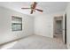 Bedroom with ceiling fan, carpet flooring, a window and entry to hallway at 1740 Shady Leaf Dr, Valrico, FL 33596