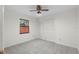 Carpeted bedroom with a ceiling fan and a window with views of exterior greenery at 1740 Shady Leaf Dr, Valrico, FL 33596