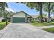 Inviting front of home, showcasing a well-maintained lawn, stone details, and attached garage at 1740 Shady Leaf Dr, Valrico, FL 33596