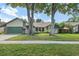 Charming single-story home featuring a lush green lawn and mature trees, blending nature and curb appeal at 1740 Shady Leaf Dr, Valrico, FL 33596