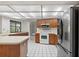 Bright kitchen boasts wood cabinets, white appliances and a large window over the sink at 1740 Shady Leaf Dr, Valrico, FL 33596