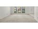 Bright living room with large windows and neutral carpeting throughout at 1740 Shady Leaf Dr, Valrico, FL 33596