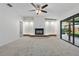 Bright living room featuring a white fireplace, ceiling fan, and sliding glass doors to a screened in patio at 1740 Shady Leaf Dr, Valrico, FL 33596