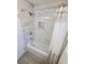 Modern bathroom with white marble-look tile, bathtub and shower combination, and gray flooring at 2432 Auburn S St, St Petersburg, FL 33712