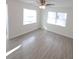 Bright living room featuring new wood-look tile flooring, ceiling fan, and lots of natural light at 2432 Auburn S St, St Petersburg, FL 33712