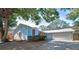Charming light blue single-story home featuring a two-car garage and well-maintained landscaping at 2580 Redwood Way, Clearwater, FL 33761