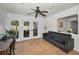 Bright living room with neutral tile, ceiling fan, French doors to the patio, and a dark sofa at 2580 Redwood Way, Clearwater, FL 33761