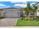 Charming single-story home features a well-manicured lawn, stone accents, and a brick driveway at 32773 Tree Of Life Ave, Wesley Chapel, FL 33543