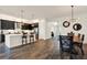 Open-concept kitchen with a large island, modern appliances, and stylish pendant lighting, flowing into the dining area at 32773 Tree Of Life Ave, Wesley Chapel, FL 33543