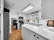 Well-lit kitchen featuring stainless steel appliances, white cabinets, and hardwood floors at 4819 W Bay Villa Ave, Tampa, FL 33611