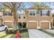 Inviting townhome exterior with a well-maintained lawn, attached garage, and a mature tree at 4944 Pond Ridge Dr, Riverview, FL 33578