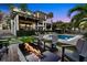 Stunning backyard featuring a sparkling pool, inviting lounge chairs, and a modern fire pit for outdoor enjoyment at 5004 S The Riviera, Tampa, FL 33609