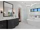 Stylish bathroom featuring a sleek vanity, soaking tub, and a glass-enclosed shower at 5004 S The Riviera, Tampa, FL 33609