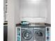 Clean and organized laundry area with washer, dryer, and overhead white cabinets at 5004 S The Riviera, Tampa, FL 33609
