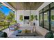 Covered outdoor living space featuring a fireplace, seating area and verdant landscape at 5004 S The Riviera, Tampa, FL 33609