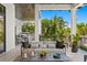 A covered outdoor seating area has plush seating, a ceiling fan, and views of a grill and the pool area at 5004 S The Riviera, Tampa, FL 33609