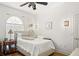 Bedroom featuring a bed, hardwood floors, a ceiling fan, and a large arched window at 5125 Magnolia Pond Dr, Sarasota, FL 34233