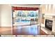 Open-concept living room with hardwood floors and a fireplace, flowing out to the screened patio and pool area at 5125 Magnolia Pond Dr, Sarasota, FL 34233