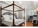 Well-lit main bedroom with a four-poster bed, hardwood floors, and a tray ceiling at 5125 Magnolia Pond Dr, Sarasota, FL 34233