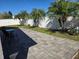 Spacious paver patio with seating, lush landscaping, and a white vinyl privacy fence at 6601 Thackston Dr, Riverview, FL 33578
