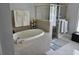 Relaxing bathroom featuring a soaking tub, glass-enclosed shower, and neutral tones at 6601 Thackston Dr, Riverview, FL 33578