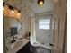 Stylish bathroom with modern vanity, patterned shower, and unique geometric wallpaper at 6601 Thackston Dr, Riverview, FL 33578