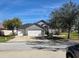 Charming single-story home with a three-car garage, lush landscaping, and a well-maintained lawn at 6601 Thackston Dr, Riverview, FL 33578