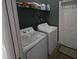 Functional laundry room with washer, dryer, storage shelf and door at 6601 Thackston Dr, Riverview, FL 33578