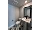 Modern half-bathroom featuring a stylish pedestal sink, decorative floor tiles and dark fixtures at 7225 Sutton Ln, Sarasota, FL 34240