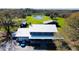 Stunning aerial view of home with metal roof, garage, and picturesque pond on expansive green property at 7705 W Four Pines Rd, Plant City, FL 33565