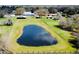 Aerial view of a serene pond surrounded by lush greenery, enhancing the property's appeal at 7705 W Four Pines Rd, Plant City, FL 33565