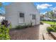 Charming backyard shed with a brick walkway, surrounded by lush greenery and landscaping at 156 21St Ne Ave, St Petersburg, FL 33704