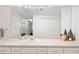 Bathroom vanity featuring white cabinets, a large mirror, and decorative accessories at 1910 E Palm Ave # 10301, Tampa, FL 33605
